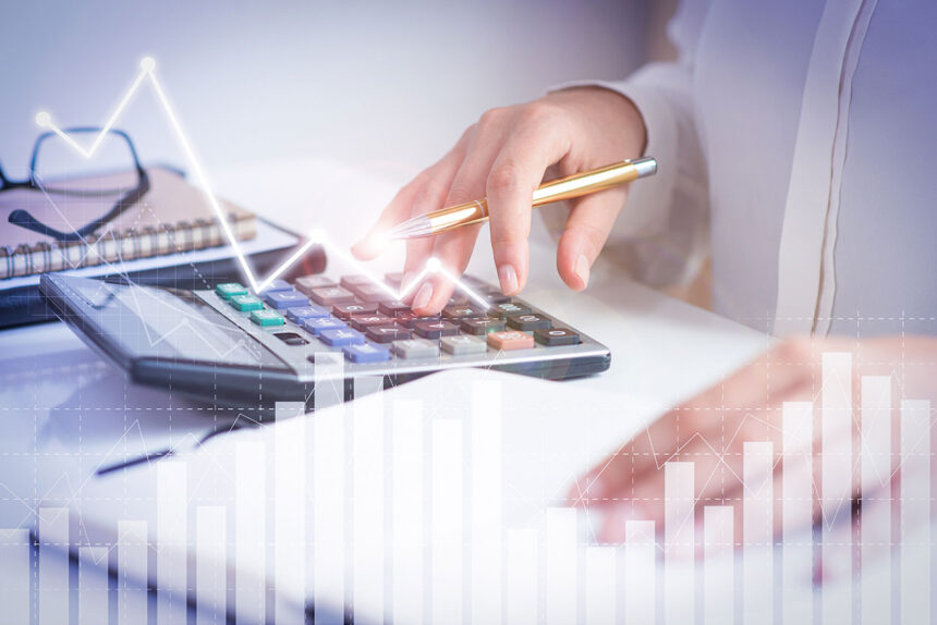 Accounting tools on a desk with a laptop, calculator, and books for small business finance management.