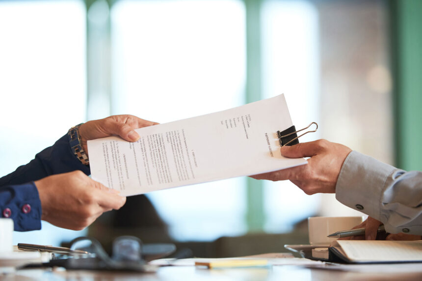 Two professionals examining paperwork to ensure HR compliance in a small business setting.